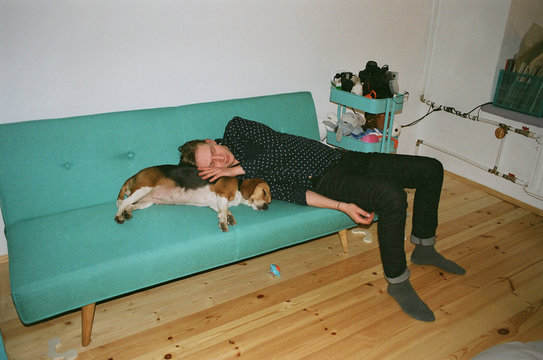 Man with a dog lying on a coach