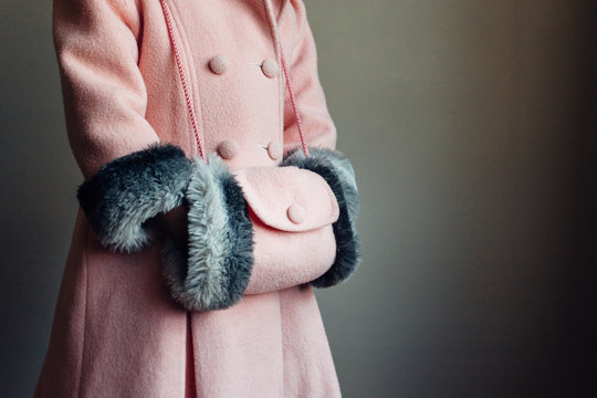 Little girl wearing a pink coat and hand muff