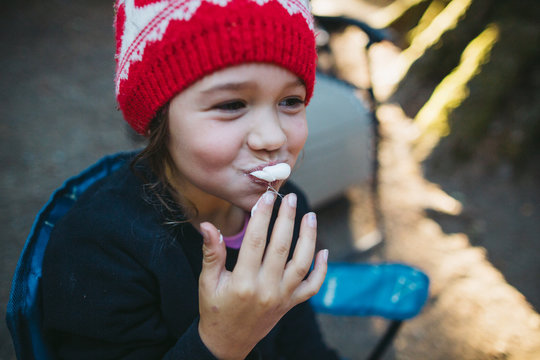 Cute little girl eating marshmallow