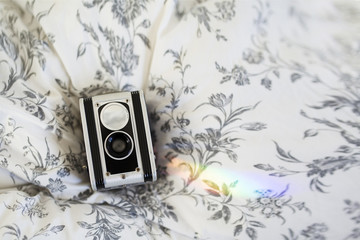 Dual camera seen from above on flowered cotton background on bed + rainbow