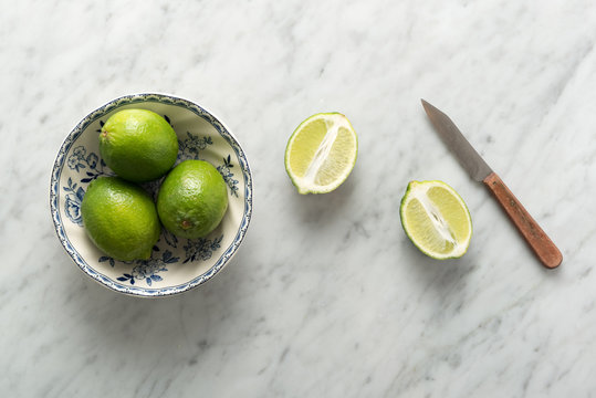 Limes on Marble Counter with Knife