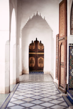 Ornate archway and door with tiled floors in Bahia palace in Marrakech.