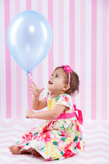 Girl with a blue ballon in studio