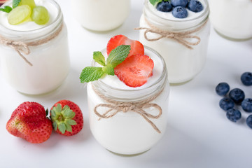 Fresh yogurt with berries in glass jars. Healthy food, dieting and breakfast concept. Close up