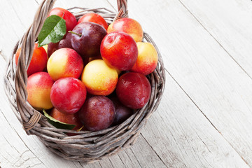 Fresh ripe peaches and plums in basket