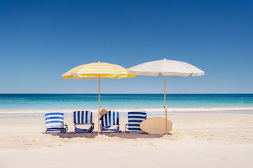 Group of four beach chairs with beach umbrellas