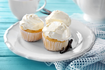 Tasty vanilla cupcakes on plate