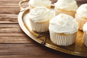 Tasty vanilla cupcakes on metal tray