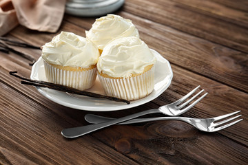 Tasty vanilla cupcakes on plate