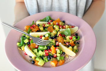 Woman holding plate with superfood salad, closeup