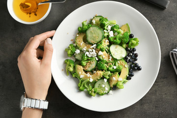 Woman with plate of superfood salad on table