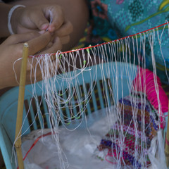 Person's hands weaving craft product