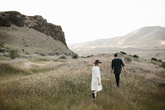 young fashionable couple walking through desert landscape