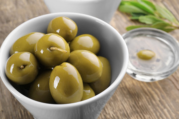 Bowl with olives on wooden table