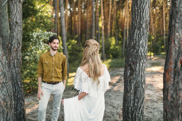 Fototapeta premium The first meeting of bride and groom. The bride goes to the groom. Autumn wedding ceremony outdoors. Artwork