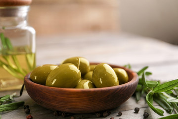 Bowl with olives on wooden table