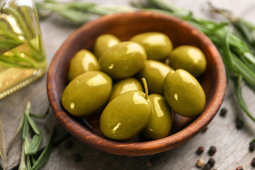 Bowl with olives on wooden table