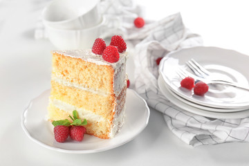Slice of delicious cake with raspberries on white table