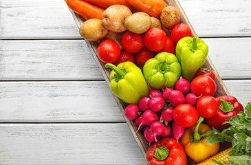 Box with fresh vegetables on wooden background