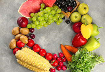 Composition with fresh vegetables and fruits on grey background