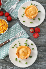 Plates with delicious meat mini pies on table