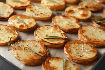 Baking tray with delicious baked potatoes, close up