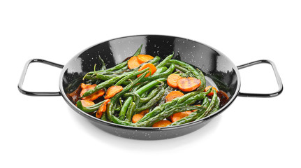 Delicious green beans and carrot slices in frying pan on white background