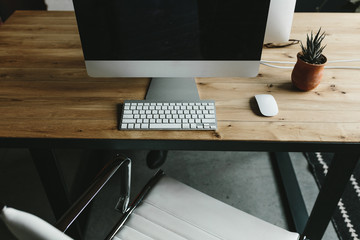 desktop computer on wood desk in bright modern office