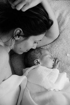 Mother and baby cuddling  on bed