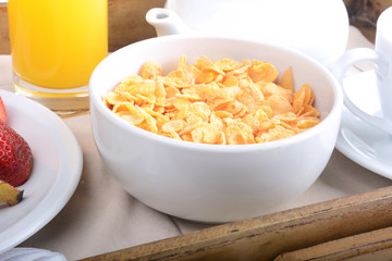 Breakfast tray with orange juice, cereals and fruits.
