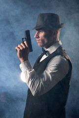 detective or criminal with gun on foggy night background