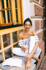 beautiful young girl drinking coffee in the city