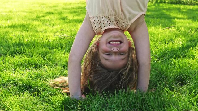 Happy child playing on green grass outdoors in spring park