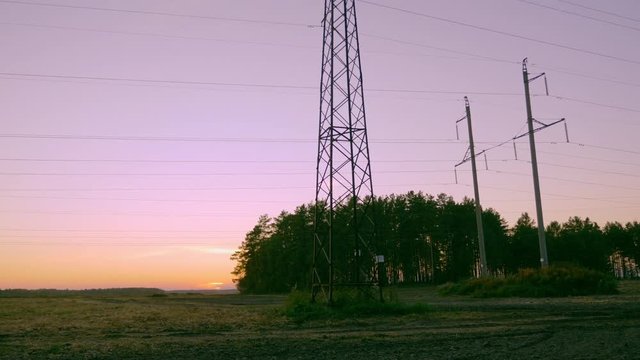 Power pylons and arable fields autumn evening outdoors.