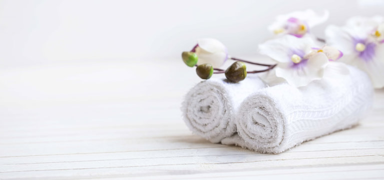 SPA setting with bath towels and orchid flower, selective focus