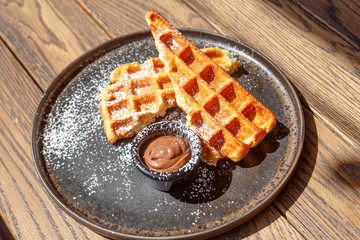 Viennese waffles with berry sauce and creme fraiche are on the plate.