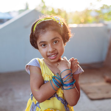 Portrait of little girl showing her blue bangles