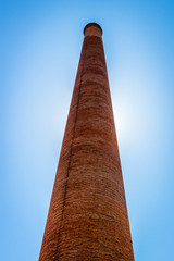 A large brick furnace back-lit by the sun