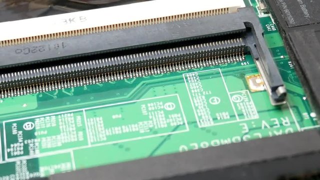 Green microchip of Laptop. Slot for ram memory dimm in notebook in the service center for repair and upgrade of computers