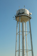 Water tower with telecommuncation devices on a blue sky