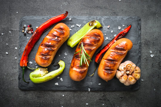 Fried bbq sausages with  vegetables at black background