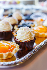 sweet table with muffins and cream on a tray