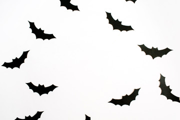 Halloween holiday concept. Handmade black paper bats on white background. Flat lay, top view.