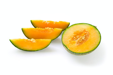 Cut halved ripe melon yellow inside, green outside. Near the cut slices with seeds. Isolate on white background.