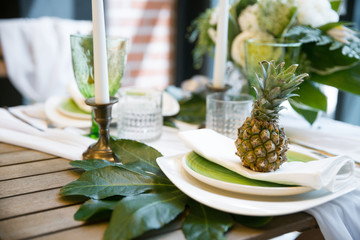 decor with a pineapples, plates, candles, green and white colours