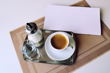 Serving coffee in the restaurant. Coffee, a glass of water and sugar on an iron tray.