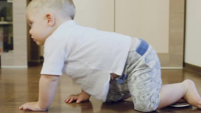 Pretty boy crawls over the parquet