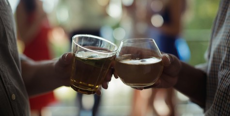 Male friends toasting cocktail glasses in restaurant