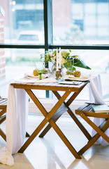 table decorated with plates, pineapples, candles and flowers, green and white colour