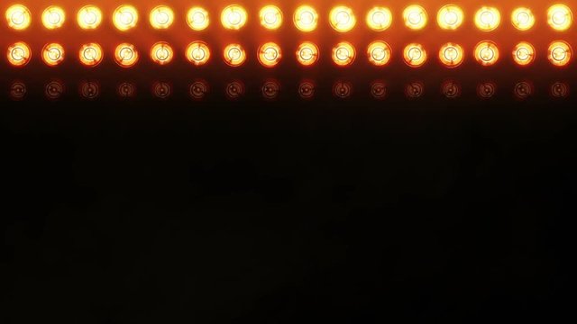 Stage lights. Close-up. Floodlights shining brightly and turning on and off. Orange. More color options in my portfolio.